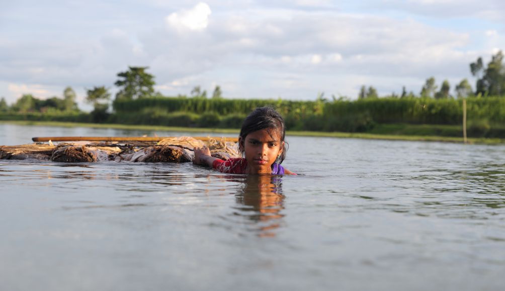 Adori, 13, has to cross flood water to attend school in her village in Bangladesh.