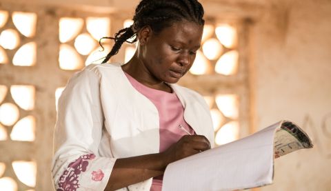 A teacher signing a copy book