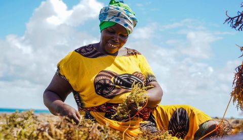 Woman happily farming and smiling down at earth