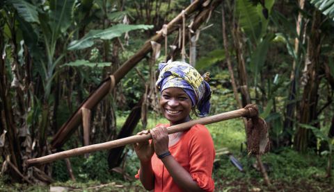 Farmer holding a spade and posing for the camera.