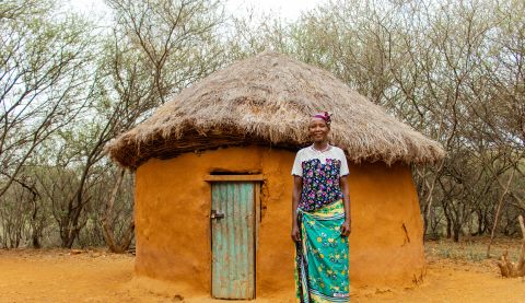 woman standing in front of a hut