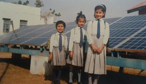 Three young girls standing and posing for the camera in their uniform 