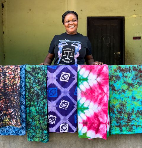woman standing in front of batik fabrics