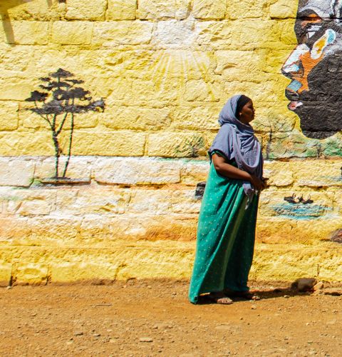 A woman standing in front of a mural