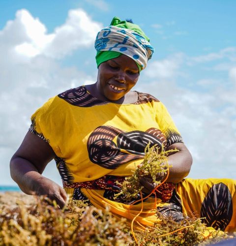 Woman happily farming and smiling down at earth