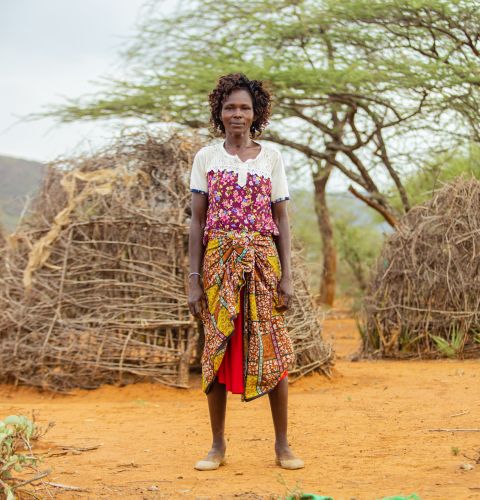 Woman standing in front of some huts
