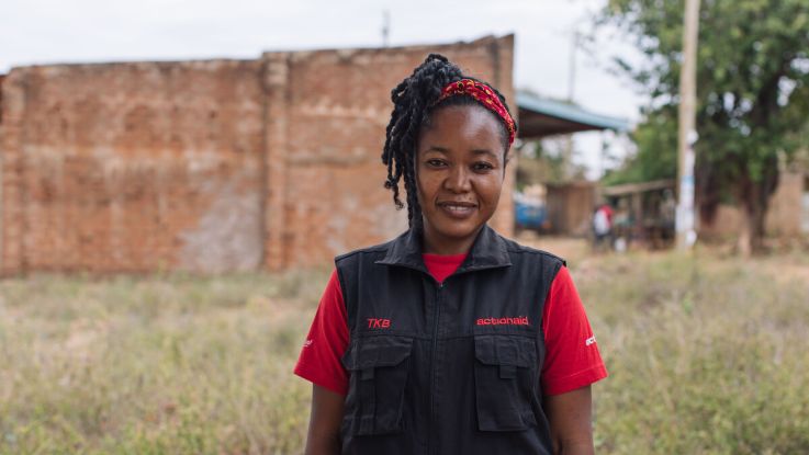 A woman in ActionAid vest smiling at camera