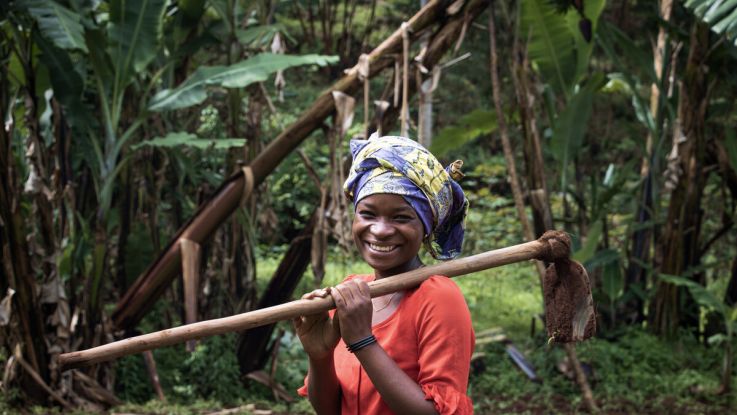 Farmer holding a spade and posing for the camera.