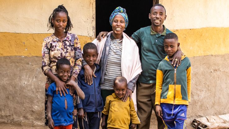 a family posing for a photo in front of their house