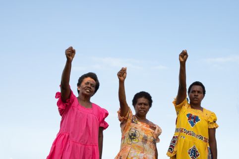 Three women holding fists up in the air